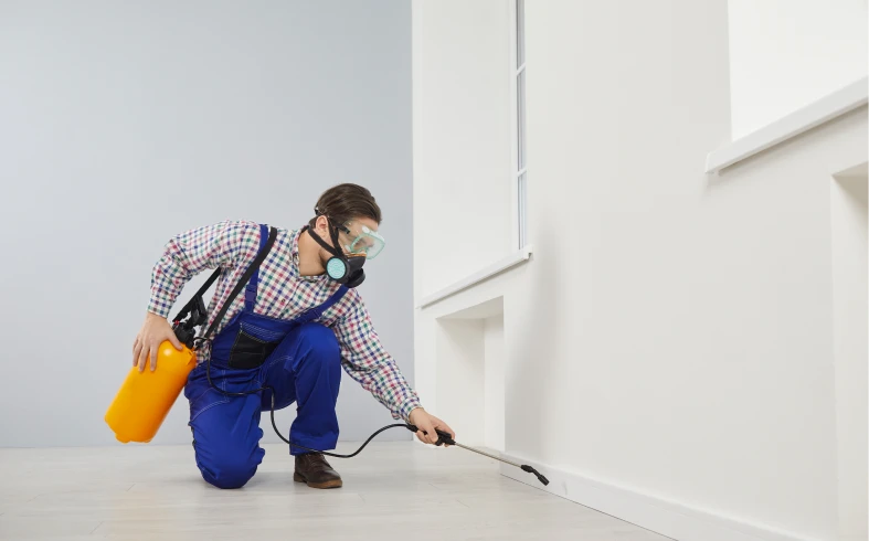 Person in safety gear applying pesticide