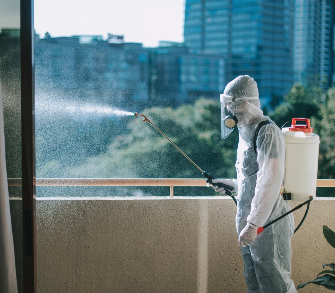 Person spraying disinfectant on balcony