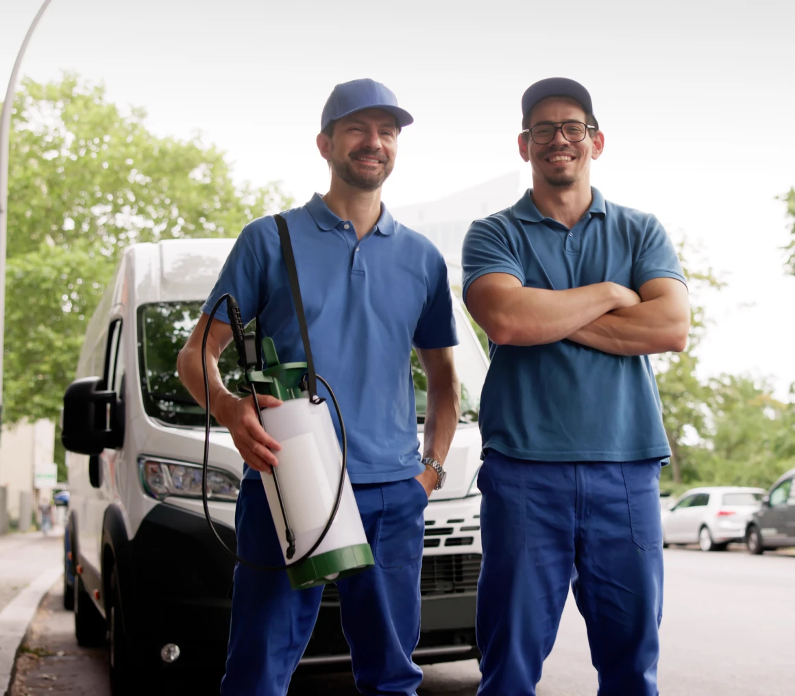 Two workers standing beside a van